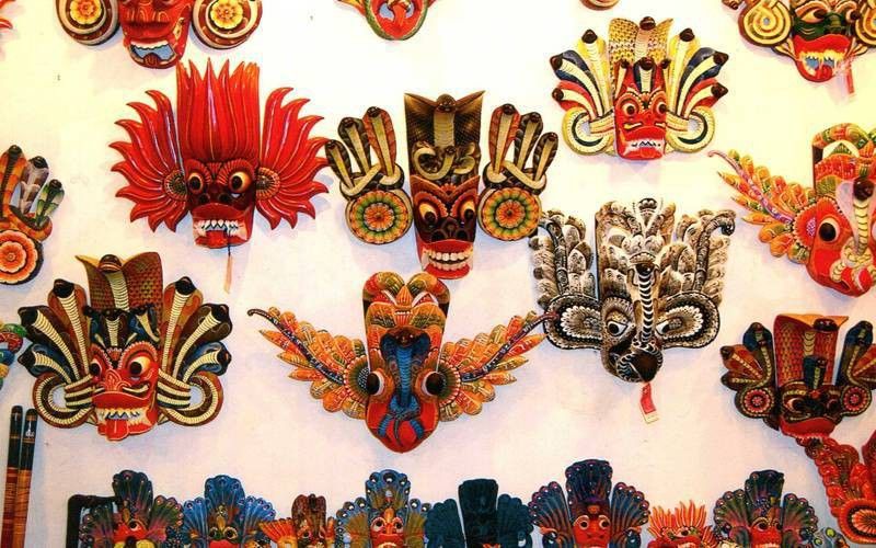 A vibrant display of traditional Sri Lankan wooden masks, including a variety of designs and colors. This cultural craft is often showcased during tours, highlighting the country's unique heritage as part of a travel package from a trusted Tour Company in Sri Lanka and a reliable Tour Operators in Sri Lanka.