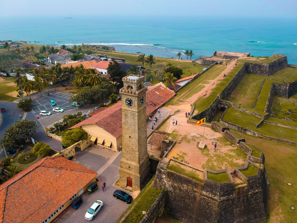 An aerial shot of the Galle Fort's historic clock tower and fortifications, with the Indian Ocean visible in the background. This UNESCO World Heritage site is a top cultural attraction, featured on tours expertly organized by the best Tour Operators in Sri Lanka and a professional Tour Company in Sri Lanka.