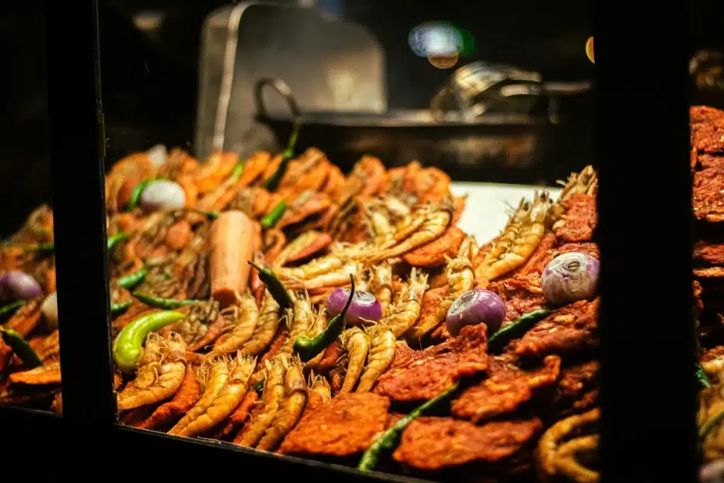 A close-up shot of a variety of fried seafood, including shrimp and other delicacies, on a food stall, representing a local gastronomic and culinary tour experience offered by Ceylon Roots, a premier Tour Company in Sri Lanka.
